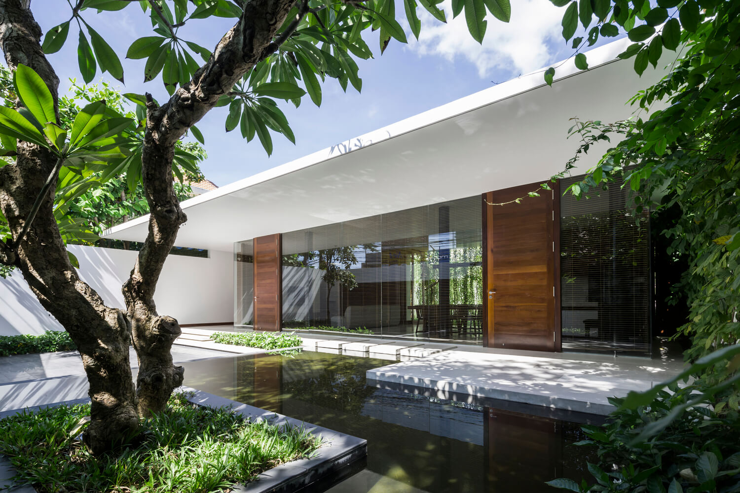 Casa Moderna + Jardim no Vietnã por MIA Design Studio 001 Fachada Jardim e Espelho d'água