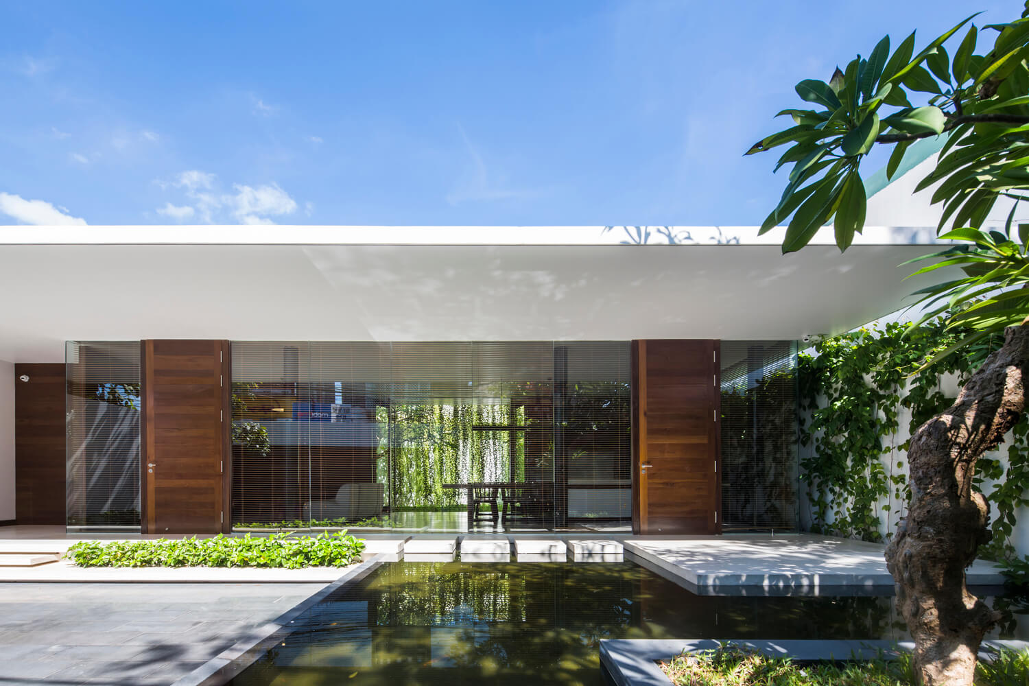Casa Moderna + Jardim no Vietnã por MIA Design Studio 002 Fachada Jardim e Espelho d'água