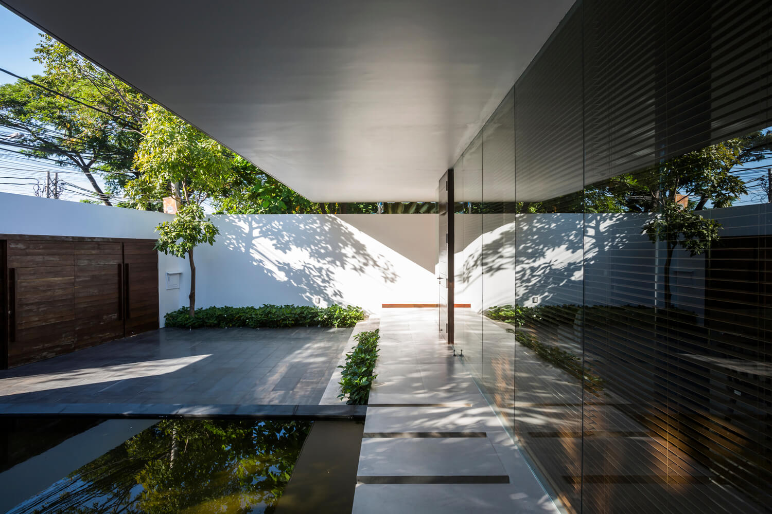 Casa Moderna + Jardim no Vietnã por MIA Design Studio 004 Fachada Jardim e Espelho d'água