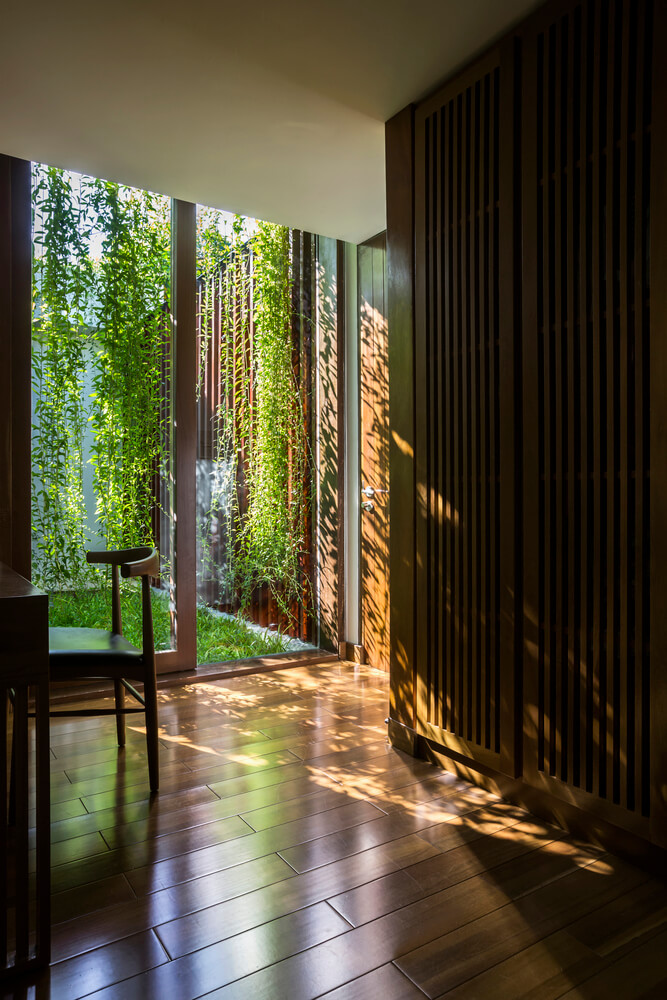 Casa Moderna + Jardim no Vietnã por MIA Design Studio 015 Quarto com Piso de Madeira e Jardim