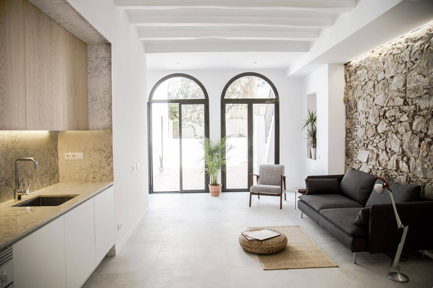 Casa reformada, Estilo Retrofit em Barcelona por RÄS studio 002 Cozinha + Parede de Pedra + Sofá