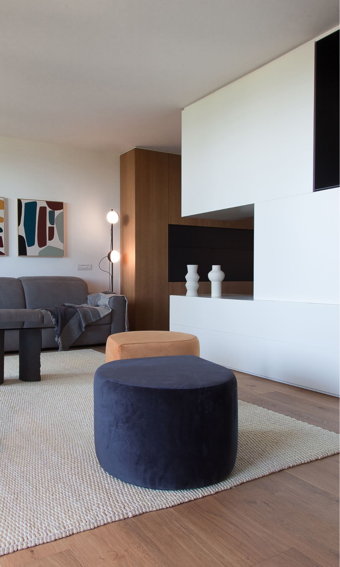 Reforma de Apartamento Moderno Llull por YLAB Arquitectos - Sala Integrada, parede azul, painel de madeirae sofá cinza