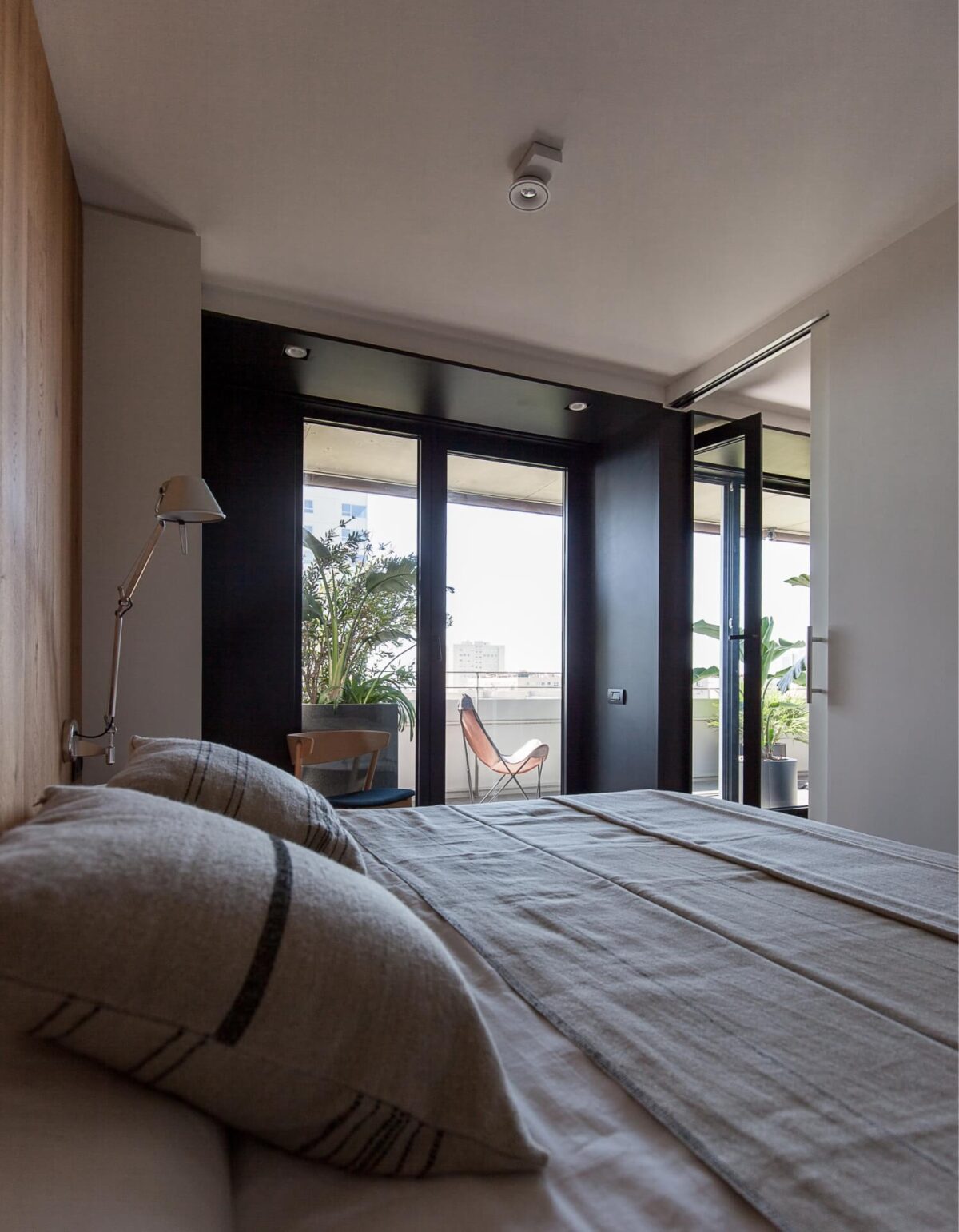 Reforma de Apartamento Moderno Llull por YLAB Arquitectos - Quarto com Suite e Sacada, painel de madeira e parede escura