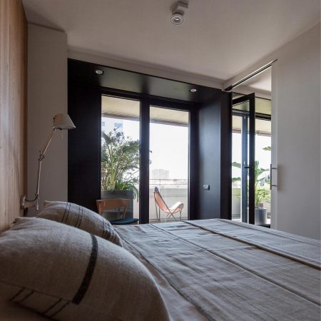 Reforma de Apartamento Moderno Llull por YLAB Arquitectos - Quarto com Suite e Sacada, painel de madeira e parede escura