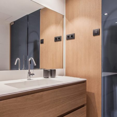 Reforma de Apartamento Moderno Llull por YLAB Arquitectos - Banheiro Suite com paredes amadeiradas e piso branco