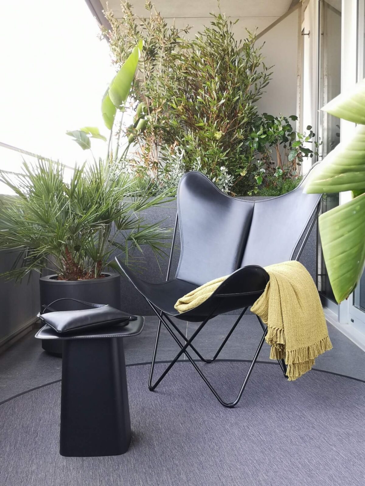 Reforma de Apartamento Moderno Llull por YLAB Arquitectos - Sacada com plantas e poltrona butterfly