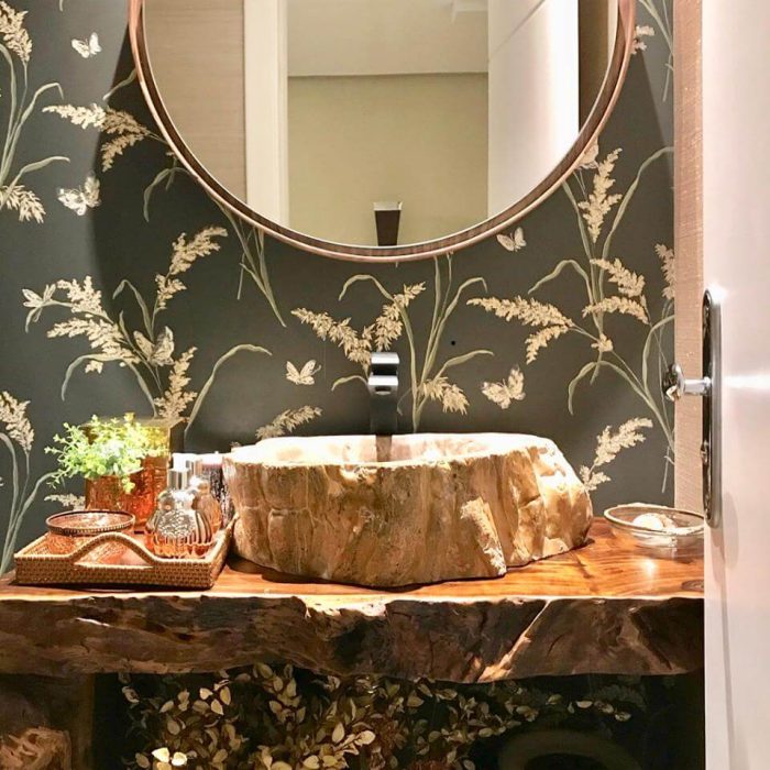 Espelho redondo com moldura em lâmina de madeira, papel de parede escuro, bancada de madeira rústica.
