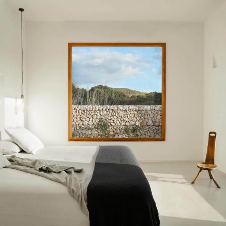 CasaE - Marina Senabre, quarto minimalista com paredes brancas e janela quadrada com linda vista para o campo.