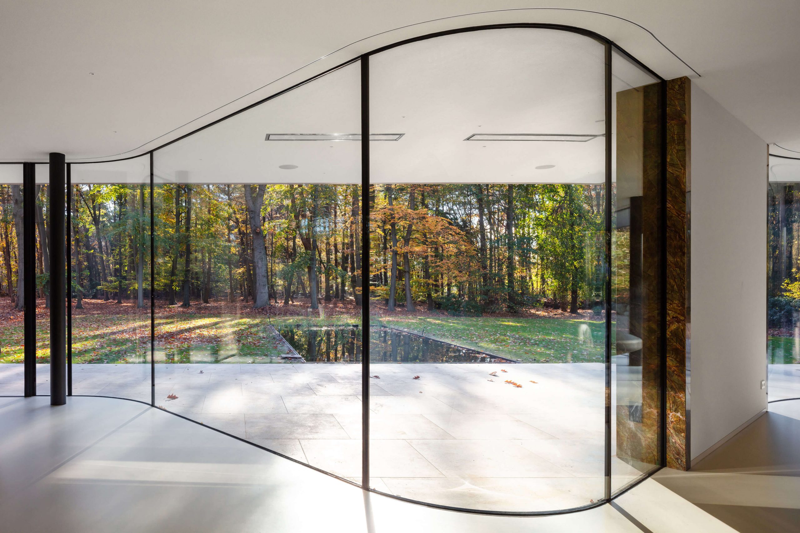 Casa Contemporânea na Holanda - Villa JM, sala de estar minimalista com vidros do piso ao teto curvo